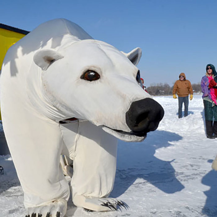 A giant polar bear puppet strikes a pose on the ice.
