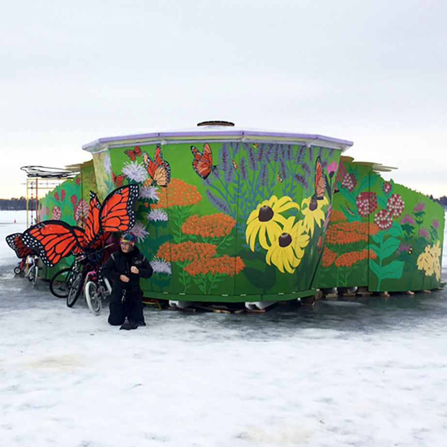 Photo of shanty painted with flowers and butterflies in the snow