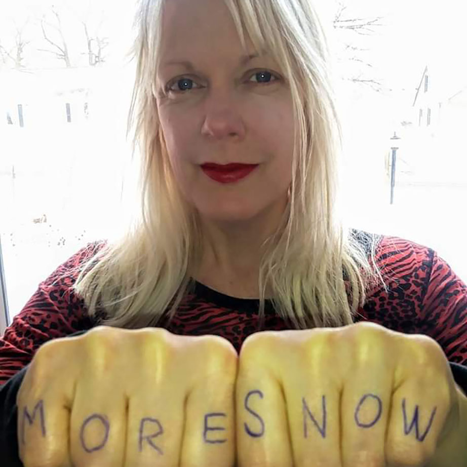 Photo of person with "MORE SNOW" written on their knuckles
