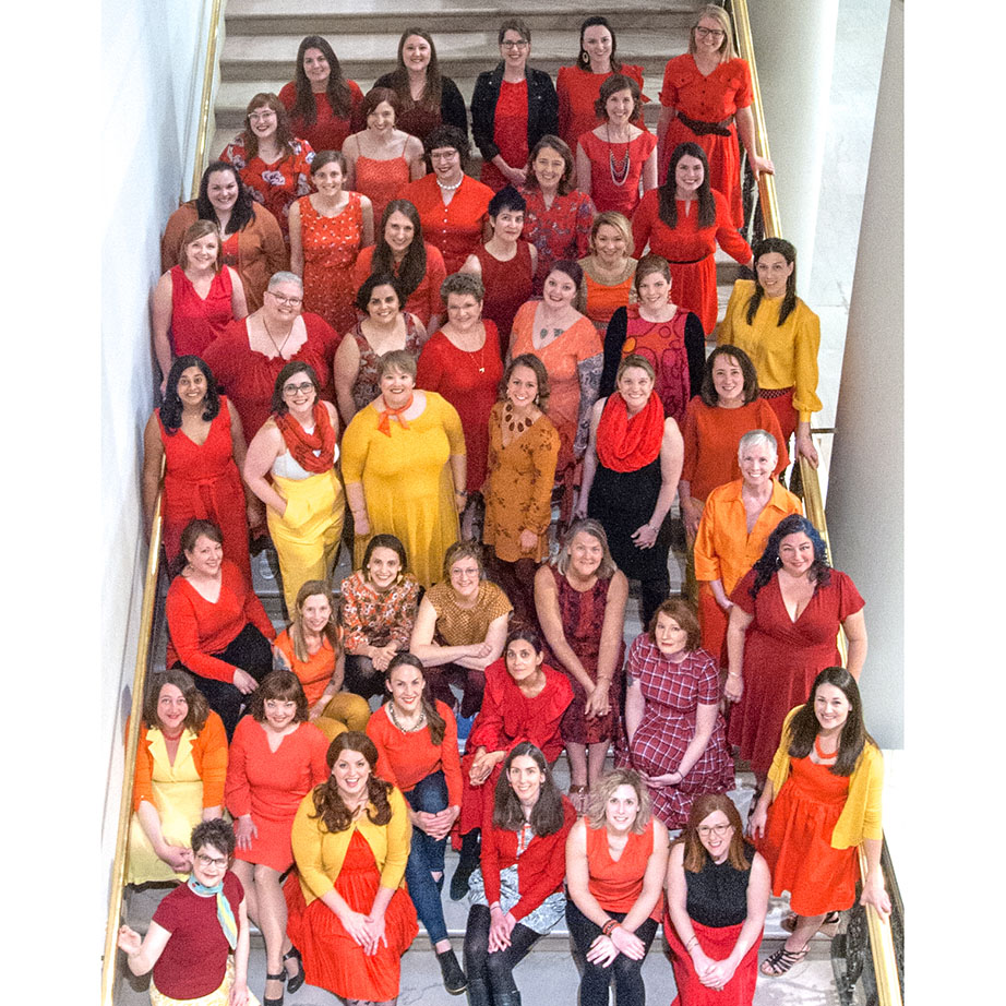 Photo of a large group of women wearing fiery colors.