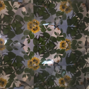 A view of yellow flowers and green leaves from inside a mirrored kaleidoscope.