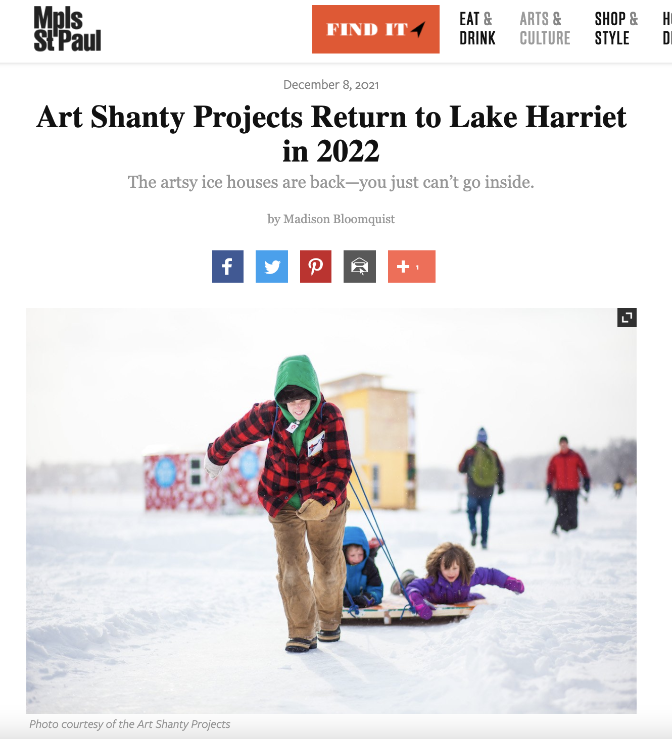 A screenshot from Mpls St Paul online magazine with an image of a person pulling kids on a sled with shanties in the background