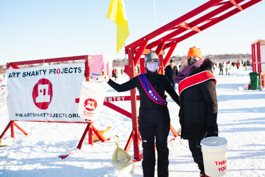 Two people with outstretched arms at the red gate