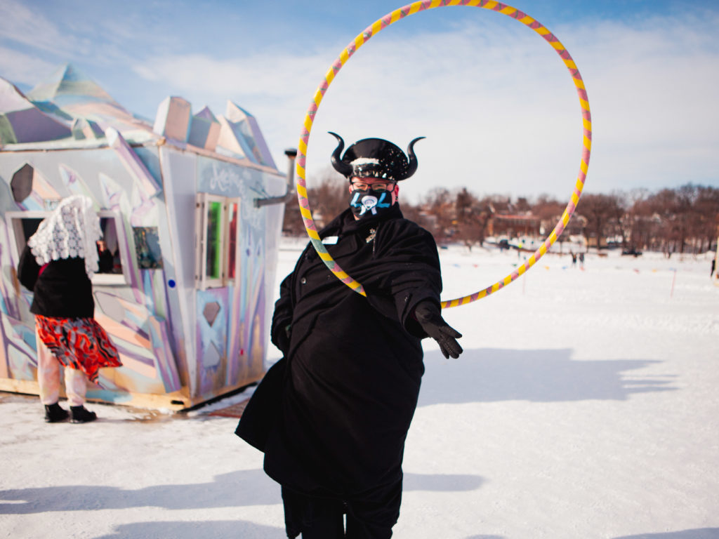 a person plays with a hula hoop in front of a crystal shaped shanty