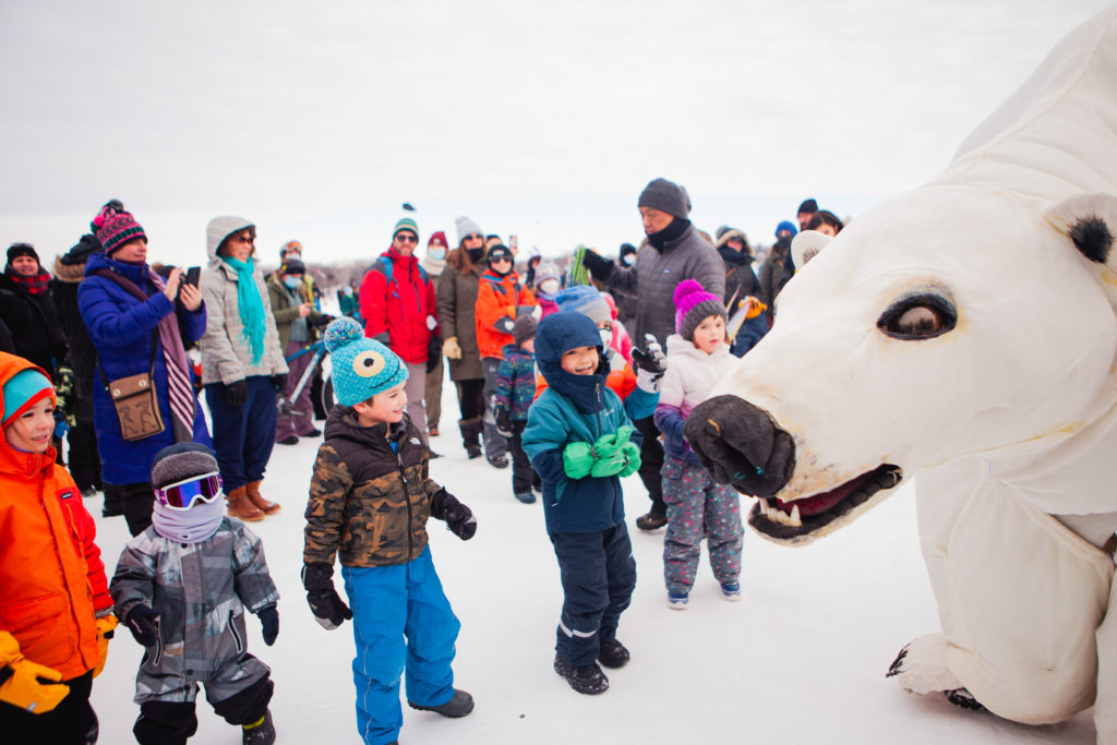 Kids look in awe at a giant polar ber puppet