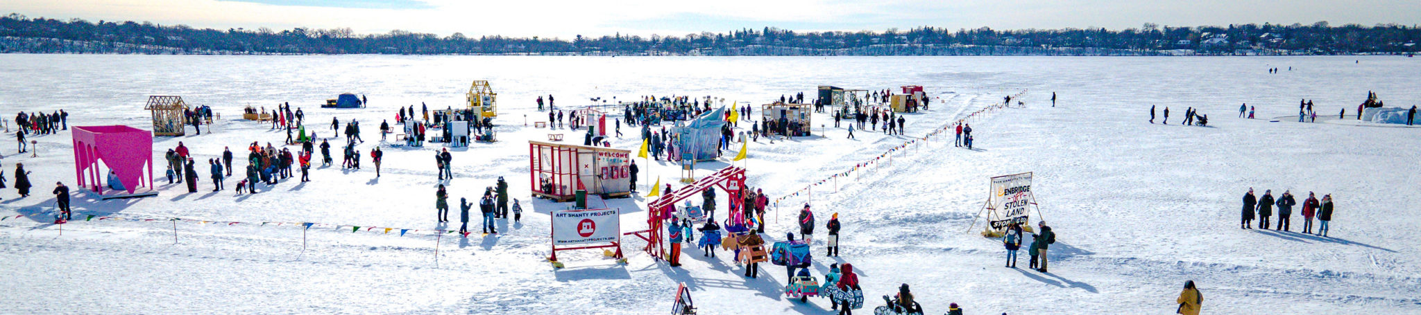 an aerial view of a busy shanty village on a frozen lake