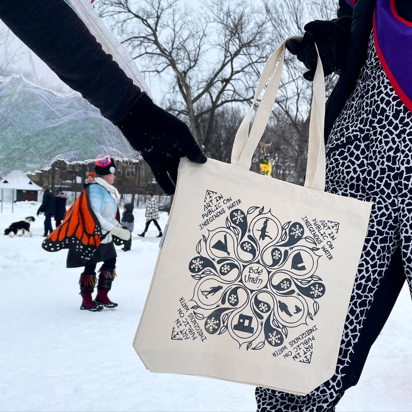 a neutral colored tote bag with a black printed design