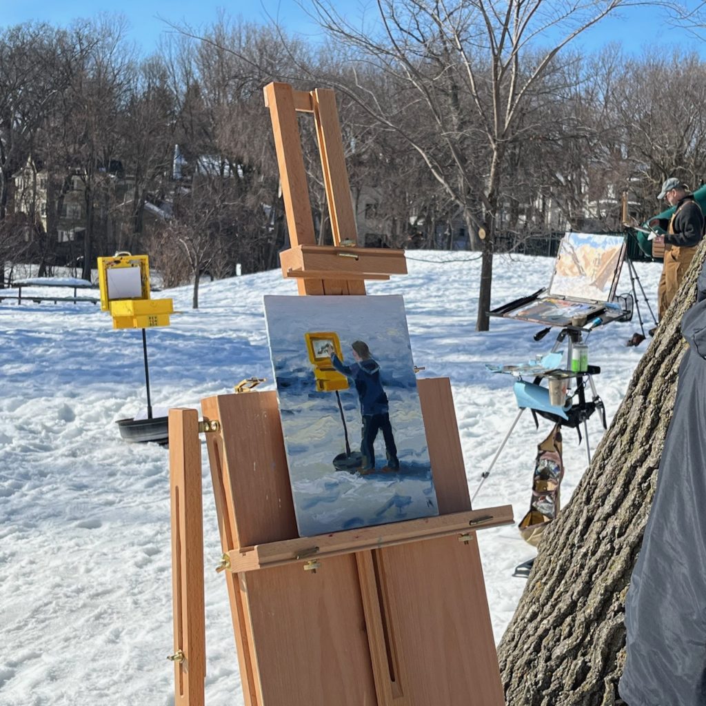 A small painting in progress on an easel - the portrait is of another person painting!