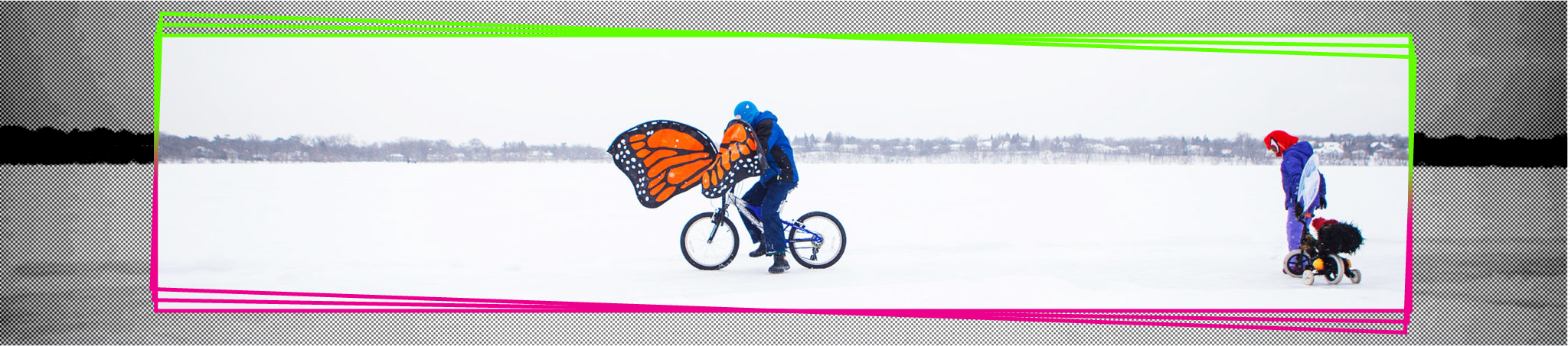 A person rides a bike on the ice. the bike has wings that look like a monarch butterfly.