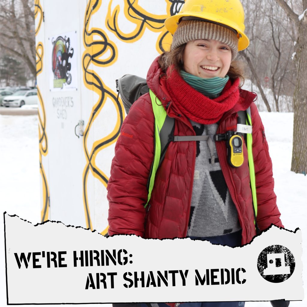 a smiling medic with a yellow walkie talkie in the art shanty village