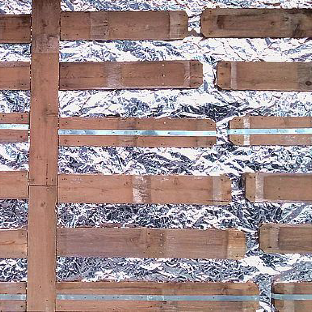 A closeup of a shanty wall panel featuring a crinkly silver background with wooden beams overlaid in a pattern