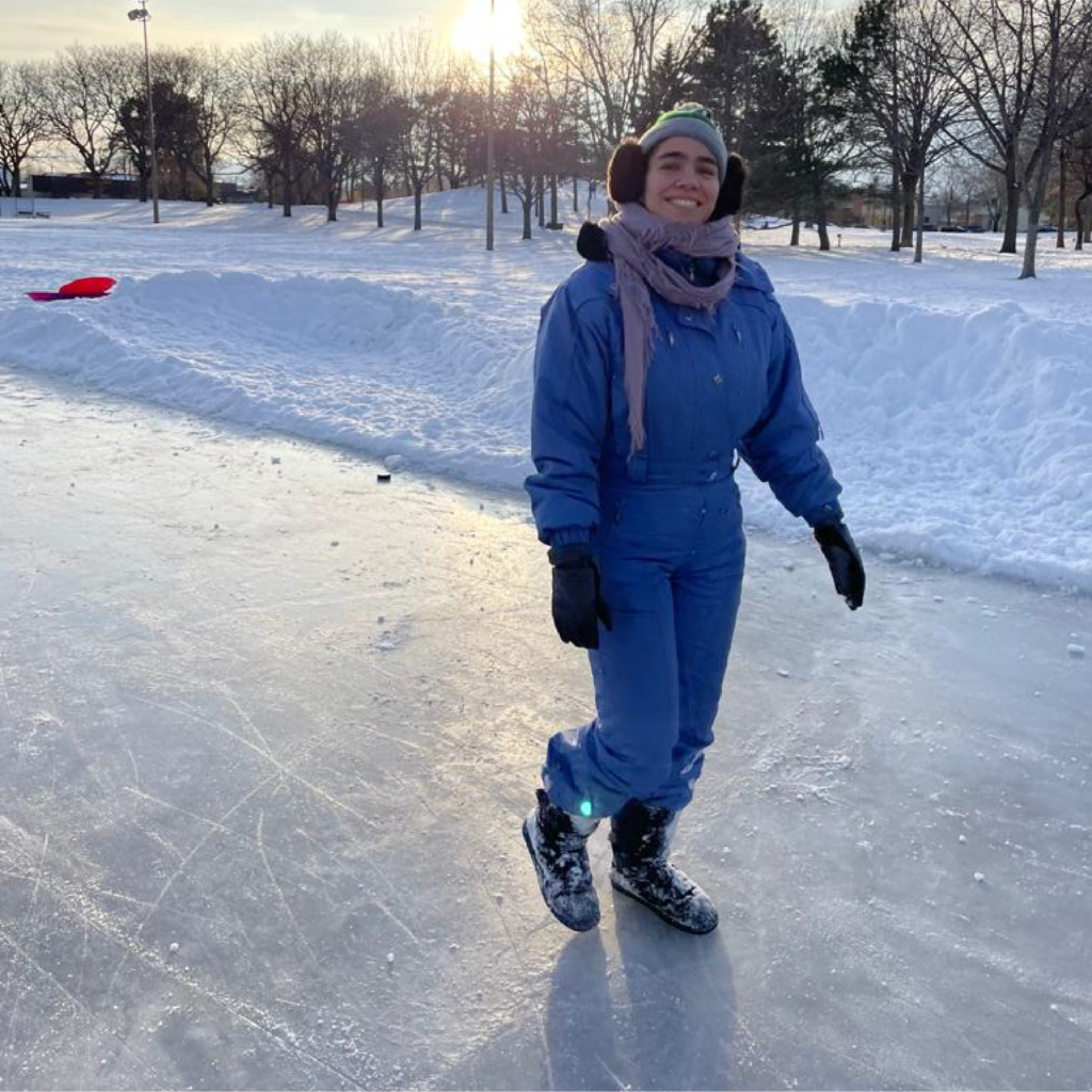 a person in a blue snowsuit walks on ice