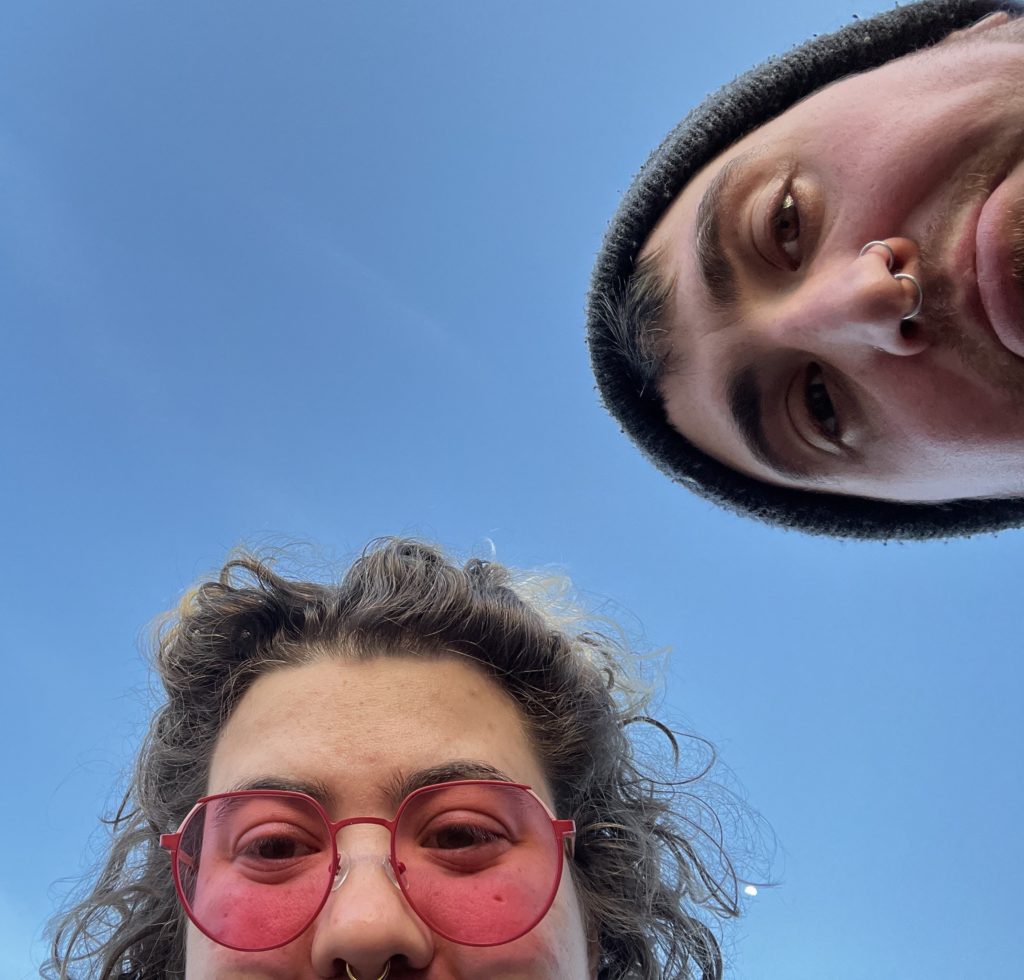 looking up, a photo of partial faces of two people with a blue sky in the background