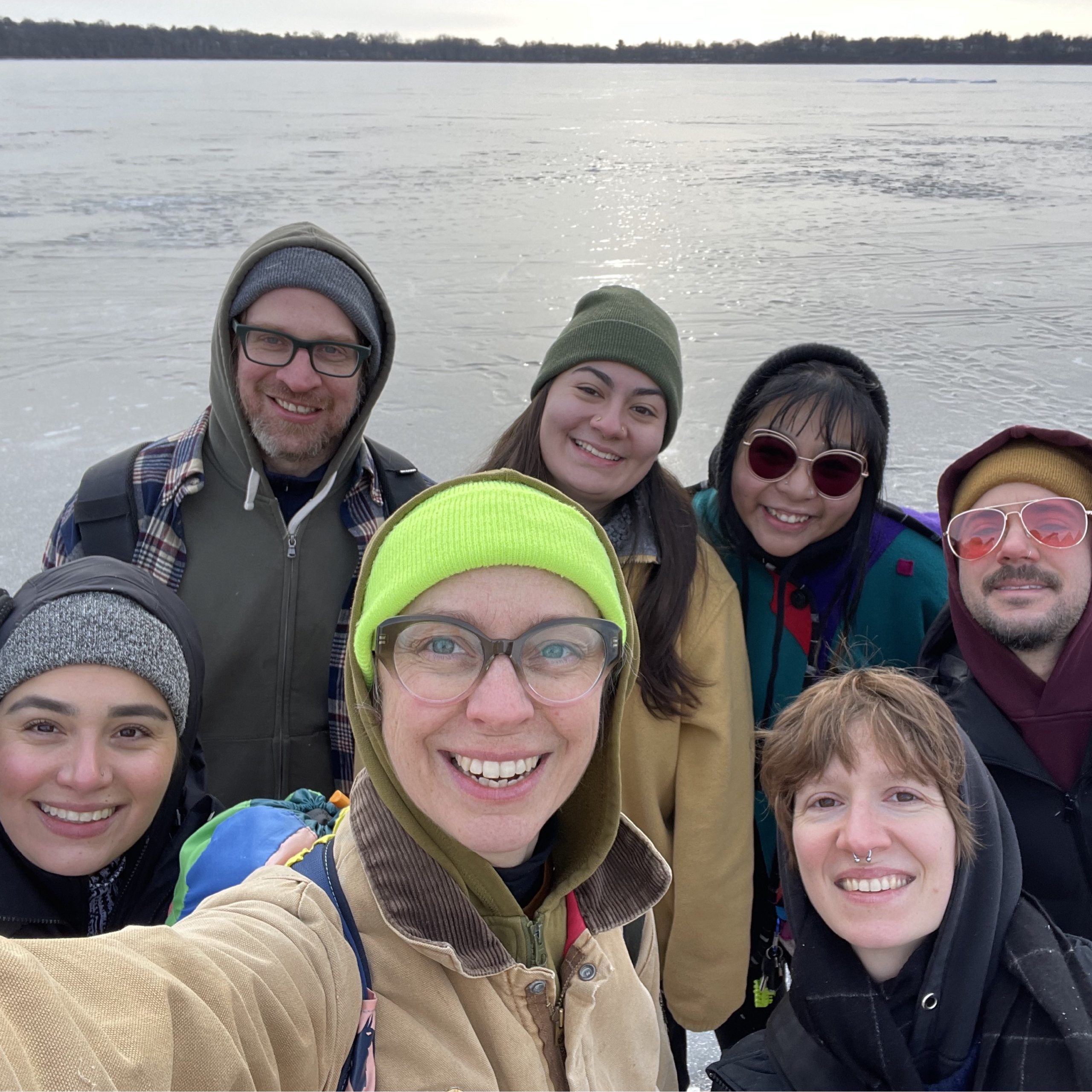 a selfie of seven staff members on the edge of the frozen lake