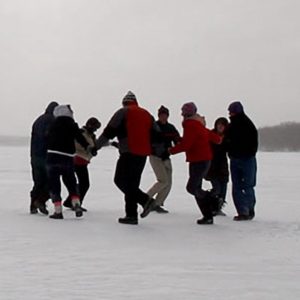 A group of people square dancing on a frozen lake
