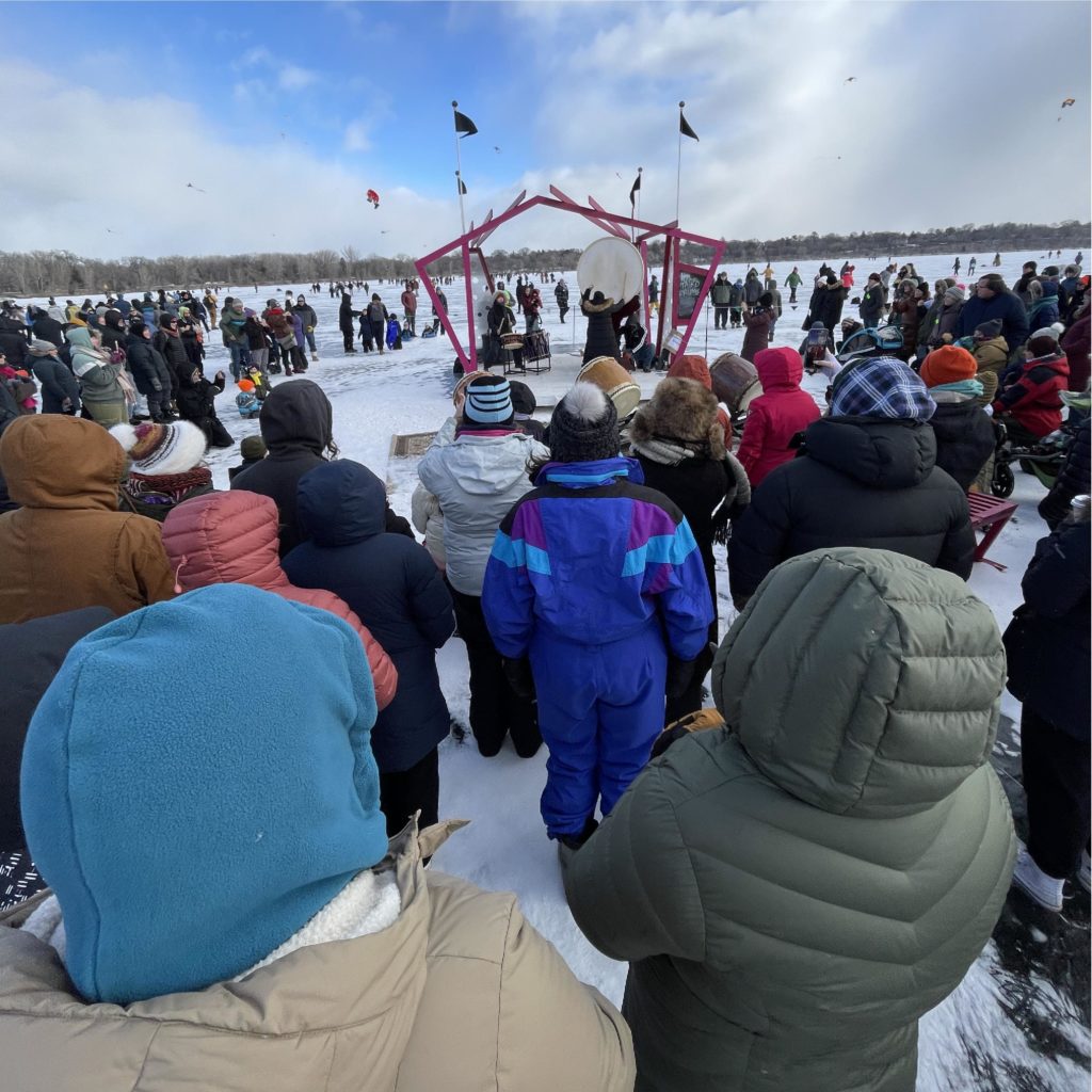 a large crowd gathers at the performance stage to listen to taiko drums