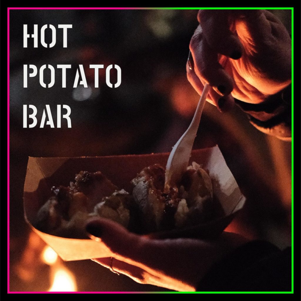 an image of potatoes in the dim firelight