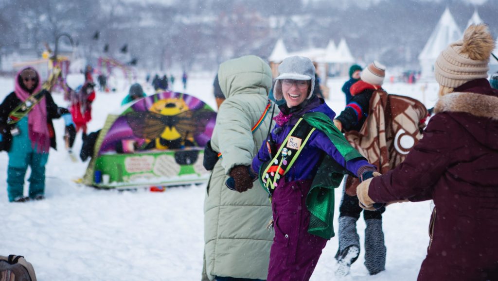 people dance in the town square while holding hands on a snowy ay