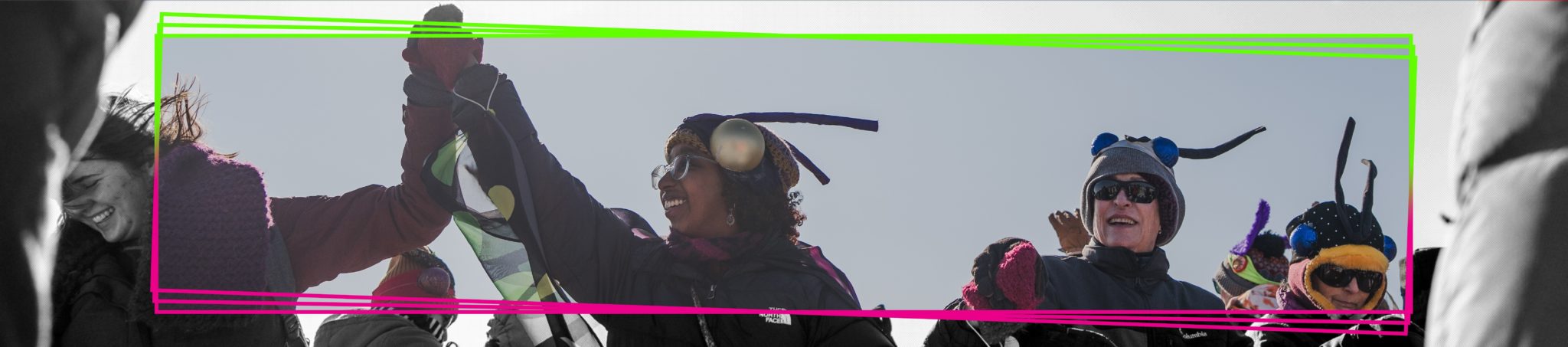 adults wearing colorful pollinator wings and antenna dance outside in the winter shanty village