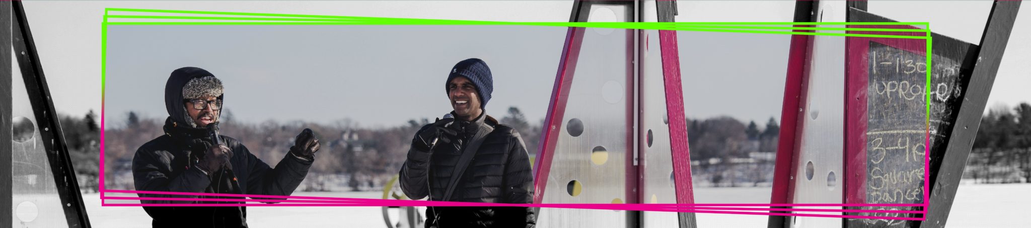 Two bundled up people with a microphone tell jokes on the open air art shanty performance stage