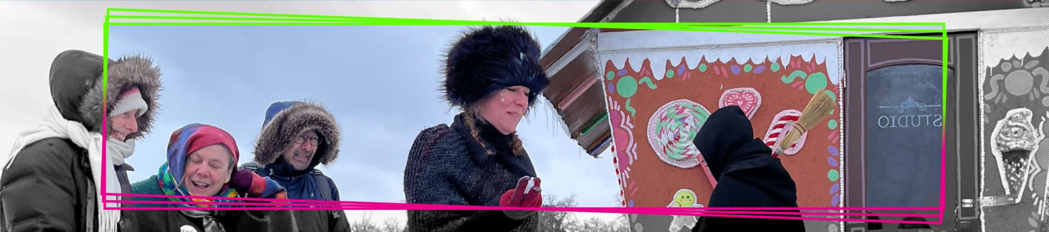 Artists dressed as witches engage with visitors outside their gingerbread house shanty
