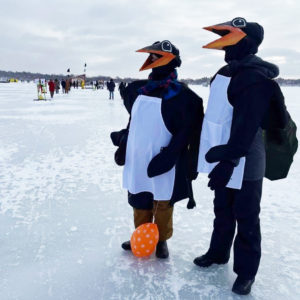 Two people dressed as penguins in the shanty village
