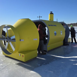 People visiting a yellow submarine shanty on a sunny day